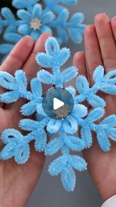 someone is holding a blue snowflake in their hands and it looks like they have been made out of yarn