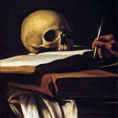 a skull sitting on top of a table next to an open book and a pen