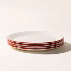 three red and white plates stacked on top of each other in front of a white background