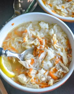 two bowls of chicken and rice soup with a lemon wedge on the side, ready to be eaten