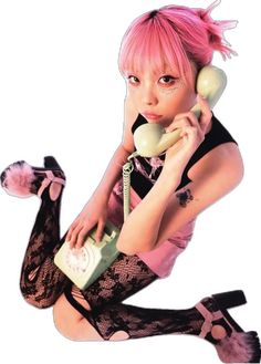 a woman with pink hair is holding an old phone to her ear and talking on the phone