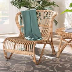 a wicker chair with a blanket on top of it in front of a potted plant