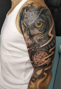 a man with an owl and clock tattoo on his arm is wearing a white tank top