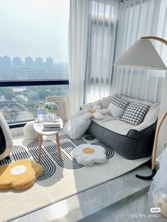 a living room filled with furniture next to a window covered in white drapes and curtains