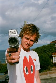 a young man holding up a camera to take a photo