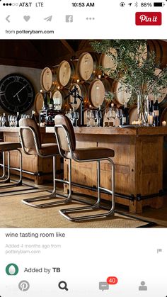 a bar with lots of wine glasses and bottles on the wall next to two chairs