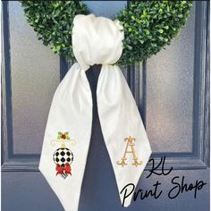 the front door is decorated with wreaths and monogrammed letters, as well as an initial