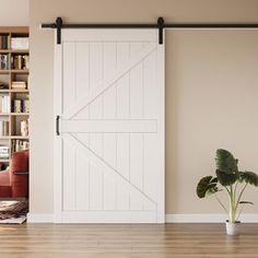 a living room with a couch, bookshelf and sliding barn door in it