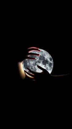 a hand holding the moon with it's fingers