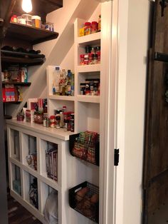 an open pantry with shelves filled with food and condiments on the wall next to it