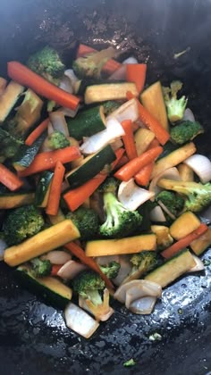 vegetables are being cooked in a wok on the stove