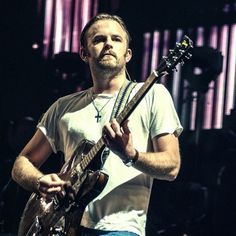 a man holding an electric guitar on stage