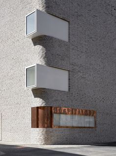 a tall white brick building with windows on the side