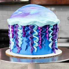 a blue and purple cake sitting on top of a counter