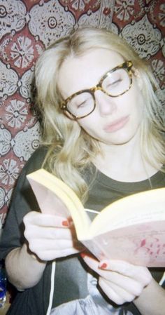 a woman wearing glasses reading a book