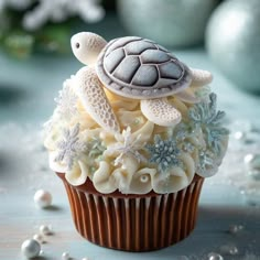 a cupcake decorated with white frosting and sea turtle decorations