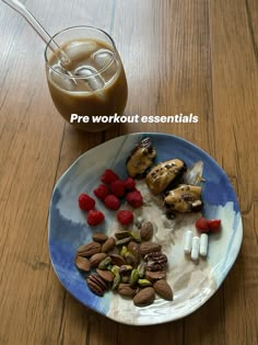 a plate with nuts, raspberries and milk on it next to a drink