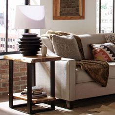 a living room filled with furniture and lots of window sill next to a brick wall