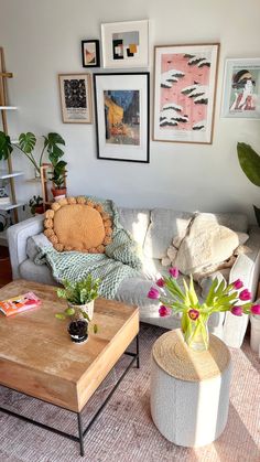 a living room filled with lots of furniture and pictures on the wall above it's coffee table