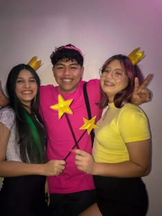 three young people posing for a photo with stars on their shirts and holding wands