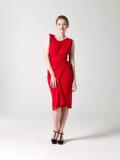 a woman in a red dress is posing for the camera with her hands on her hips