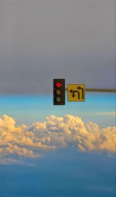 the traffic light is above the clouds in the sky