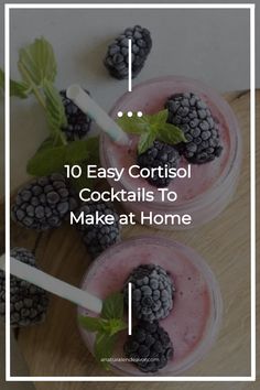 two cups filled with ice cream and blackberries on top of a wooden cutting board