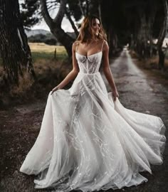 a woman in a white dress is walking down the road