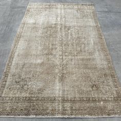 an old rug is laying on the ground in front of a concrete flooring area