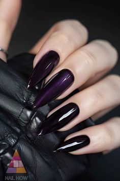 Embrace elegance with these almond-shaped dark purple nails. The high-gloss finish pairs beautifully with a chic black outfit for a timeless look. For more purple nail designs, head over to nailhow.com. Coffin Dark Purple Nails, Black Nails Purple Glitter, Black Purple Nails Ideas, Dark Purple Aesthetic Nails, Purple Inspired Nails, Nail Black And Purple, Nail Inspo Purple And Black, Nail Inspo Dark Purple, Pretty Dark Nails