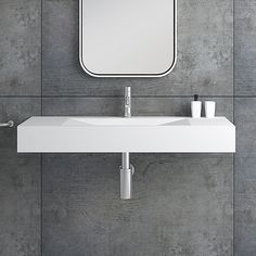 a white sink sitting under a bathroom mirror next to a wall mounted faucet