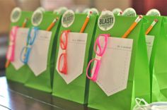 green bags with pink and blue glasses on them are lined up to be used as notepads