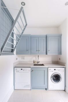 a washer and dryer in a small room with stairs leading up to the second floor