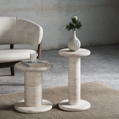 two white vases sitting next to each other on top of a carpeted floor