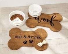 two personalized dog mats with their names on them, one has a bone and the other has a cat's food bowl