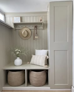 an entryway with baskets and hats on the shelf, along with two white vases