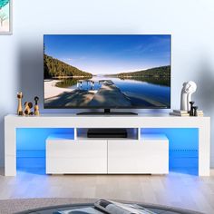 a flat screen tv sitting on top of a white entertainment center in a living room