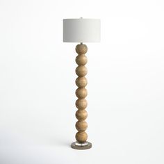 a wooden lamp with a white shade on the top and bottom part, sitting in front of a white background