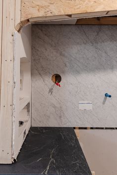 an unfinished bathroom with marble walls and flooring