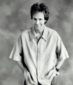 a black and white photo of a man in a short sleeved shirt with his hands on his hips