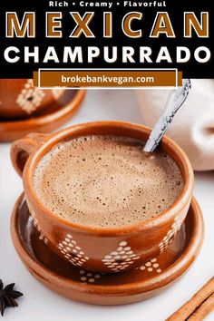 a cup of mexican chapurado with cinnamon sticks in the foreground and an orange background