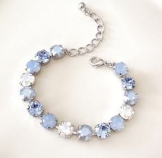 Bracelet featuring 8mm round light blue opal, dusty blue opal, dusty blue crystal and moonlight crystals. So pretty! Shown in silver, available in gold or rose gold plated. Please select metal finish from the drop down menu at checkout. Adjustable between 6 1/2 and 8 inches in length. Thanks for stopping by! Blue Jewlery, Light Blue Bracelet, Light Blue Necklace, Quinceanera Jewelry, Peach Earrings, Light Sapphire, Blue Accessories, Jewelry Bridesmaid, Prom Jewelry