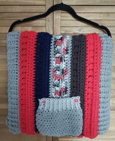 a crocheted bag hanging on a wooden door