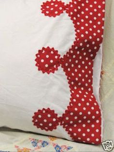 a red and white polka dot pillow with the letter e on it's side