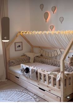 a child's bed with a canopy and lights above it