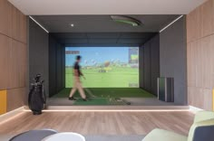 a man is playing golf on the simulator