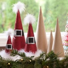 three gnome hats sitting on top of a window sill next to a christmas tree