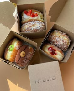 three boxes filled with pastries sitting on top of a table