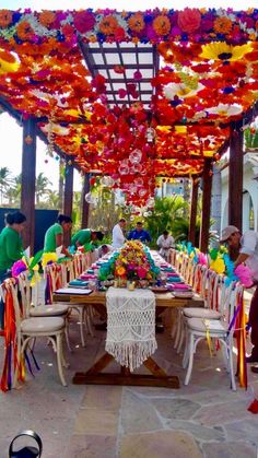 an outdoor dining area with tables and chairs covered in colorful streamers