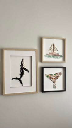 three framed pictures hang on the wall with beaded seahorses and seashells